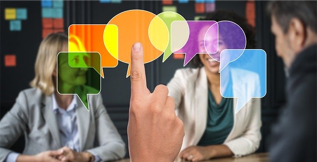 A finger pointing to colorful chat boxes