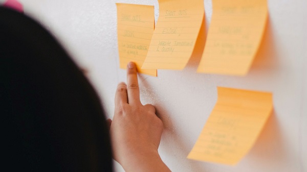 A manager pointing to a board containing business challenges the company must overcome